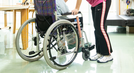 秋桜の介護職員が車椅子に乗る利用者さまをサポートしている様子