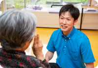 入居者さまと秋桜の介護職員がお話をしている様子